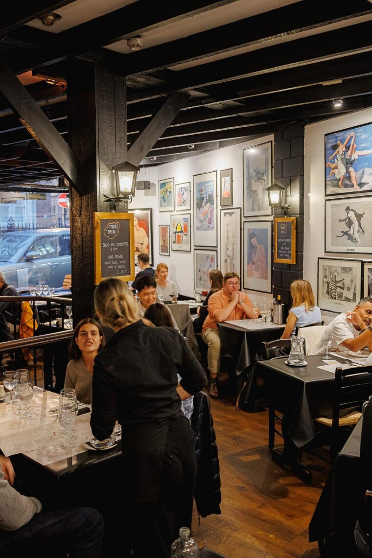 Guests enjoying traditional Spanish sharing plates in a warm and inviting dining room.