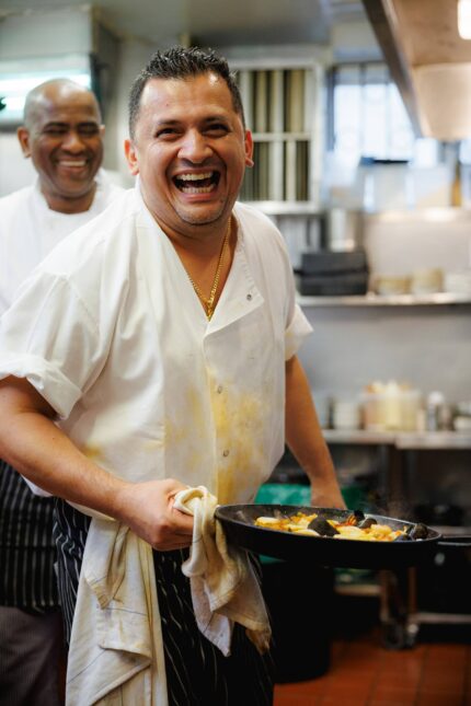 Chefs in kitchen preparing small plate tapas classic dishes in London