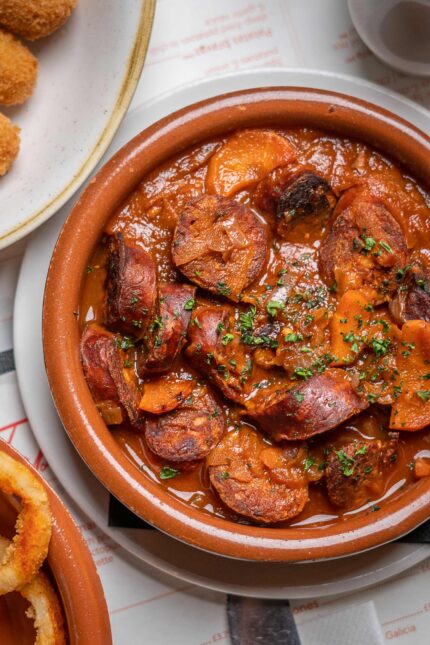 Set lunch menu Spanish tapas chorizo in traditional terracotta dish