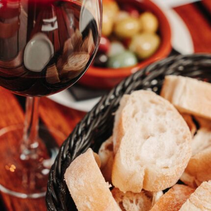 Copa de vino tinto español, pan y aceitunas.