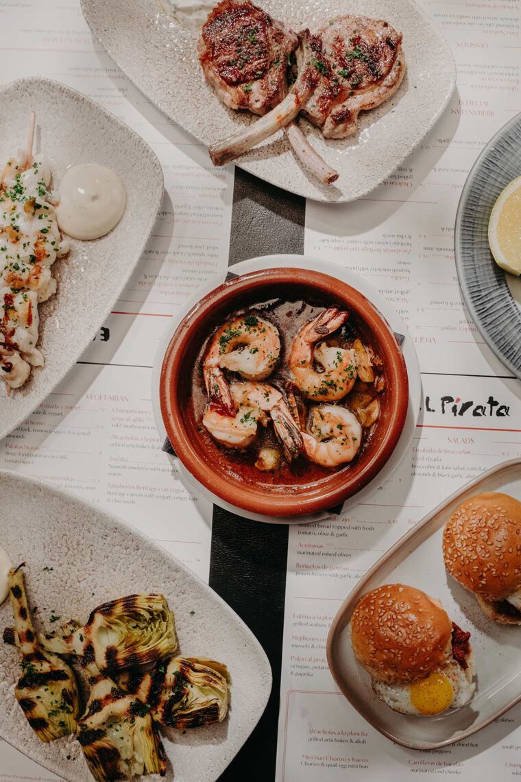 A table full of shared tapas small plates during an evening dinner.