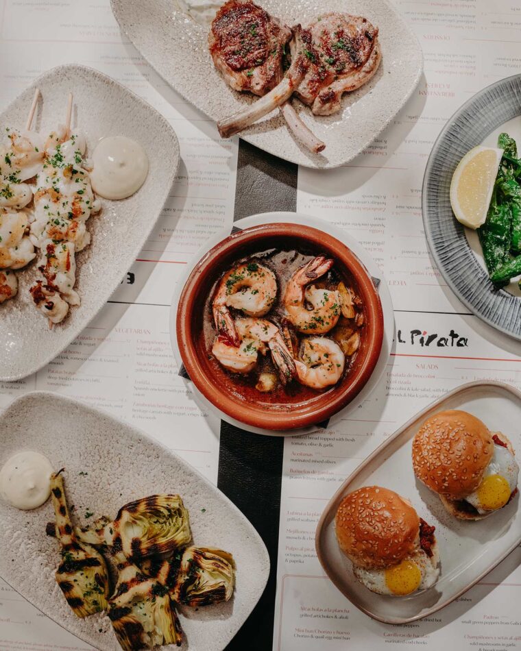 A table full of shared tapas small plates during an evening dinner.