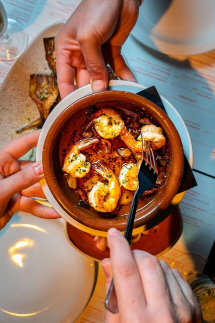 sharing dishes tapas prawns in garlic served at the bar happy customers