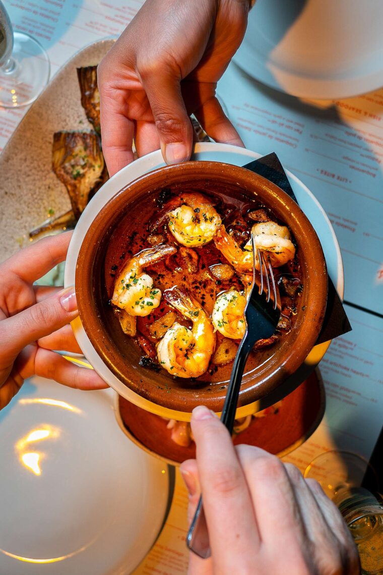 sharing romantic dishes tapas prawns in garlic
