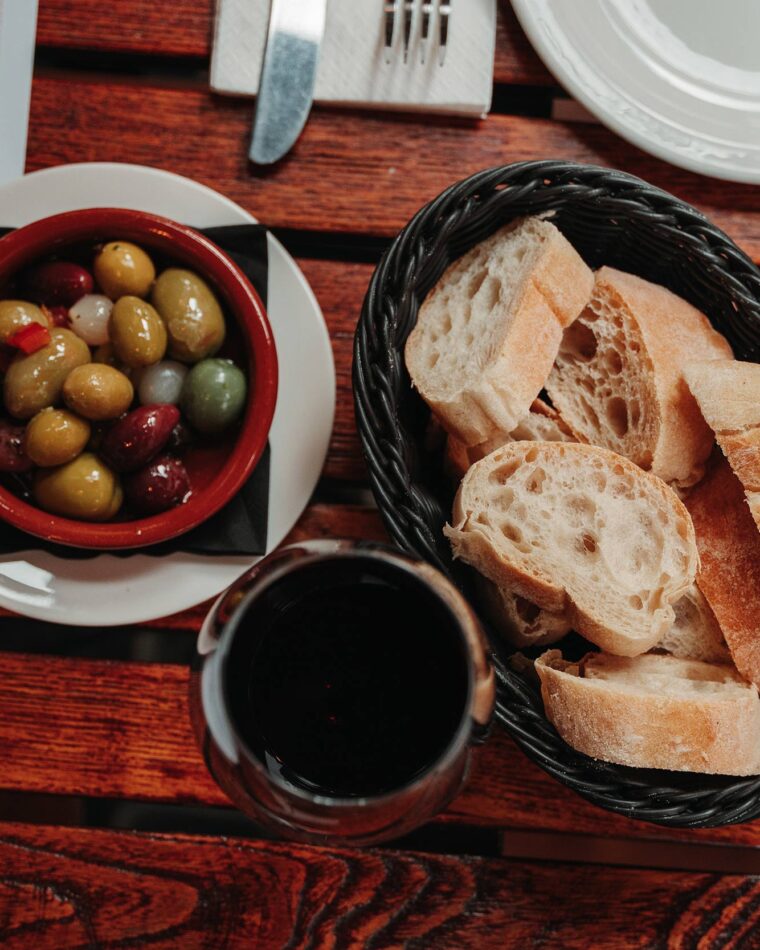 Glass of Spanish red wine bread pan olives table outside our Tapas bar