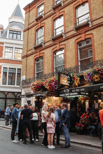 A group of friends gathering for drinks outside the tapas bar.