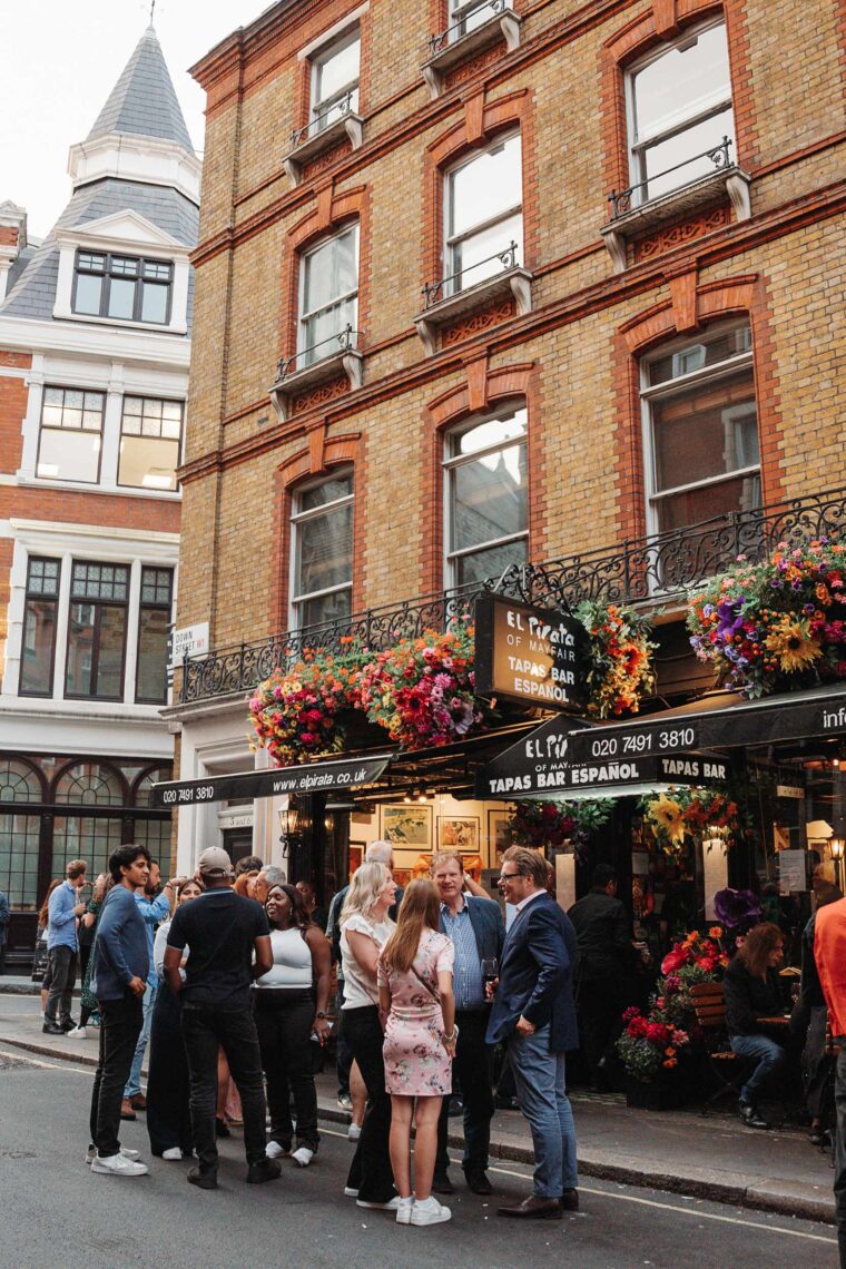 A group of friends gathering for drinks outside the tapas bar.