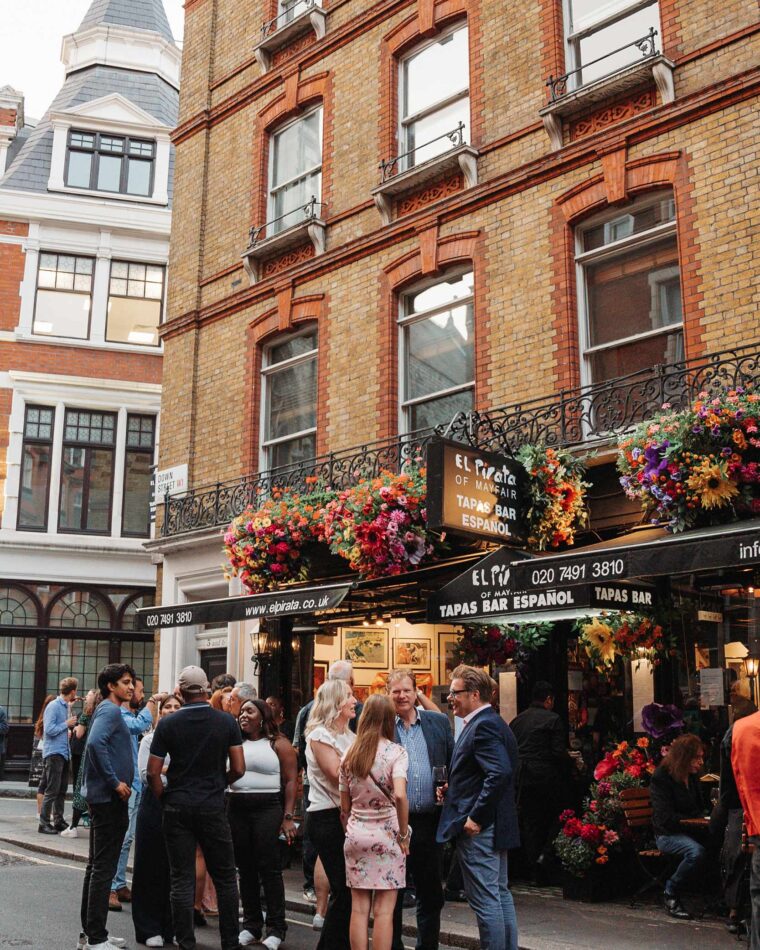 A group of friends gathering for drinks outside the tapas bar.