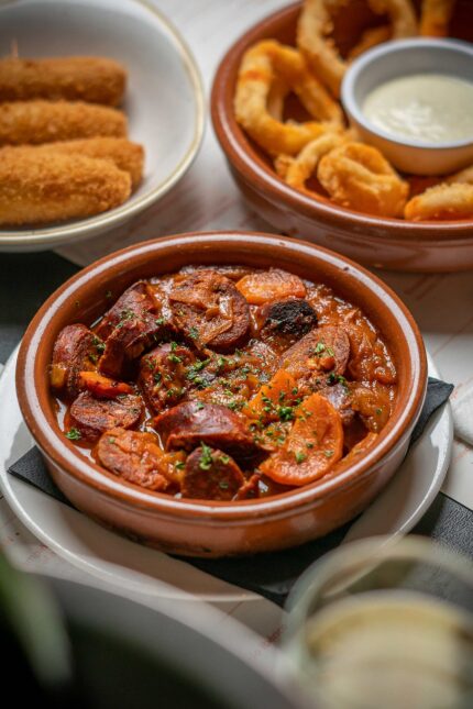 Spanish tapas chorizo calamaris in traditional terracotta dishes