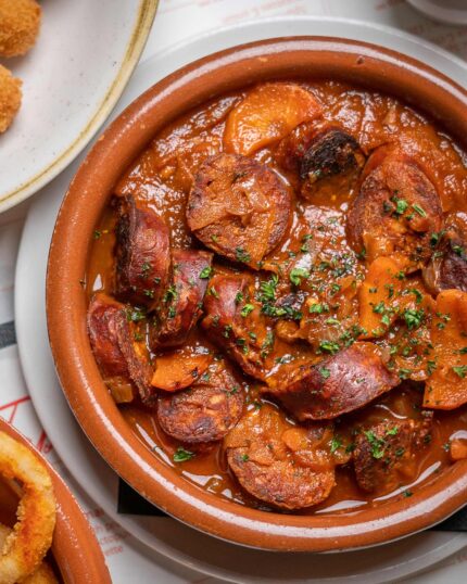 Spanish tapas chorizo in traditional terracotta dish