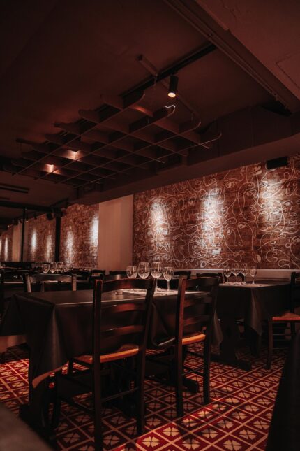 A long restaurant table fully set with glasses and plates for a large group.